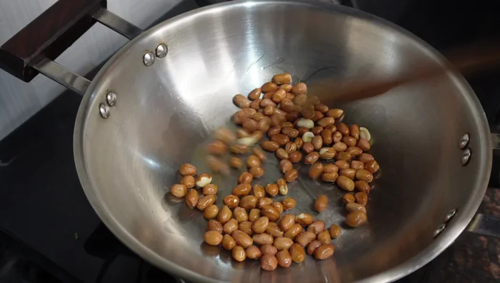 Roast peanuts in a pan over low heat with 1-2 teaspoons of oil until they're golden brown and fragrant. Stir frequently to prevent burning.