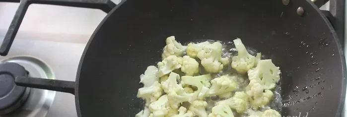 Add the cauliflower, salt, and a little turmeric powder. Mix well.