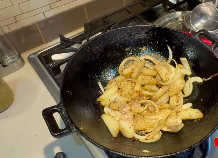 Add dry coriander, salt, turmeric, red chili powder, and dry mango powder (optional) to the potatoes and onions and mix well (693.279).