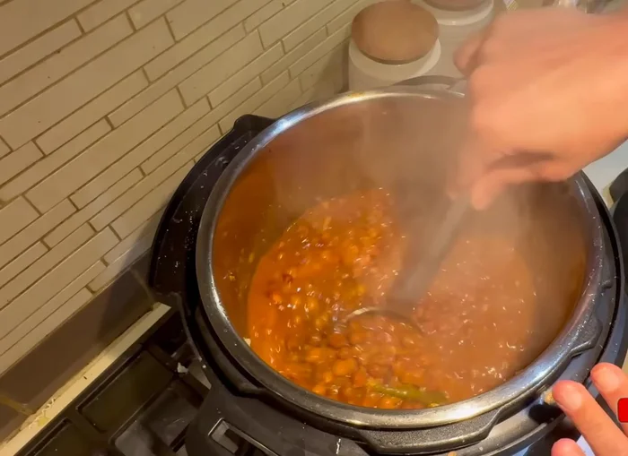 Once the chickpeas are cooked, mash them slightly with a ladle (769.279).