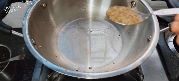 Heat oil in the pan, add cumin seeds, and sauté until they crackle. Add the crushed garlic and fry until brown and crisp.