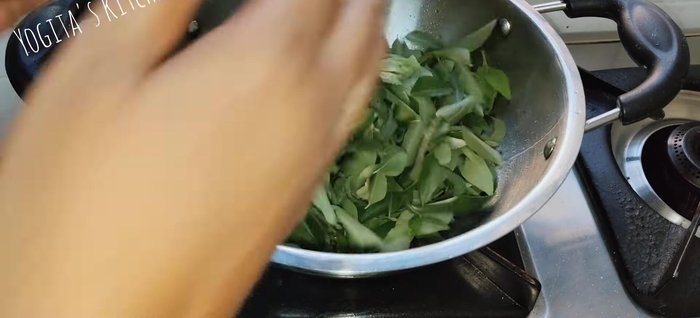 Heat one spoon of oil in a pan. Add the dried curry leaves and roast them well on low flame, pressing with a spoon to ensure even frying until lightly browned.