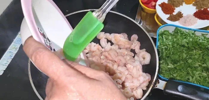 Add one spoon of oil to the pan and add prawns to drain out excess water.