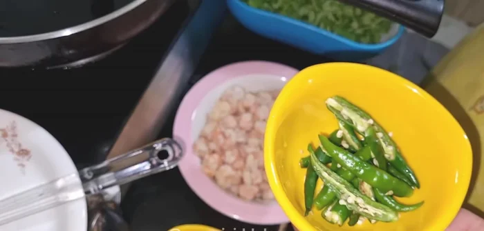 Add curry leaves and green chilies to the hot oil.