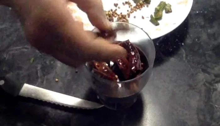 Grind the fried chilies, coriander seeds, and fenugreek seeds into a fine powder using a mixie.