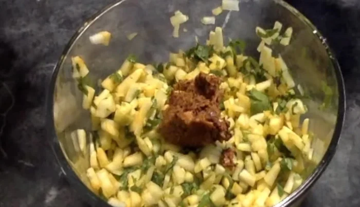 Add the paste to the chopped cucumber pieces, along with jaggery. Mix well.