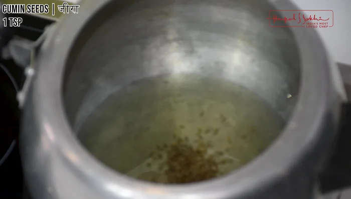 Heat ghee in a pressure cooker. Add cumin seeds, bay leaves, and black peppercorns. Sauté until fragrant.