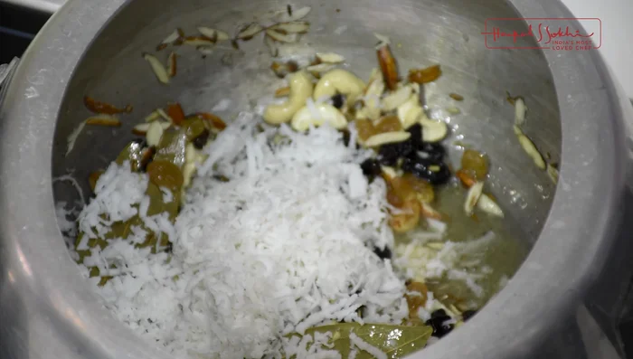 Add grated fresh coconut to the pressure cooker and sauté briefly.