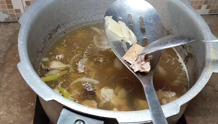 Strain the cooked beef, separating the meat from the spices and broth (yakhni).