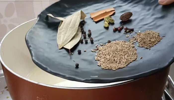 Heat oil in a pan and add cumin seeds, royal cumin seeds, small cardamom, big cardamom, cloves, bay leaves, and cinnamon; crackle them.