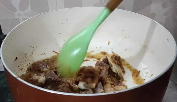 Add the cooked mutton to the onion-spice mixture, along with some water. Cook until the meat is well roasted.