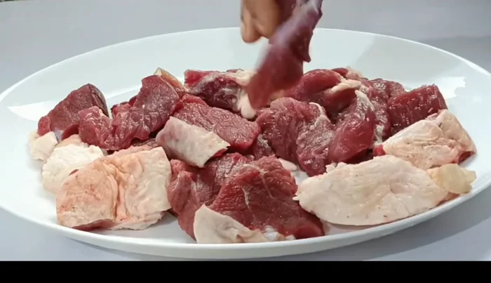 Wash the mutton and boil it in a pressure cooker with whole spices, salt, and water until tender.