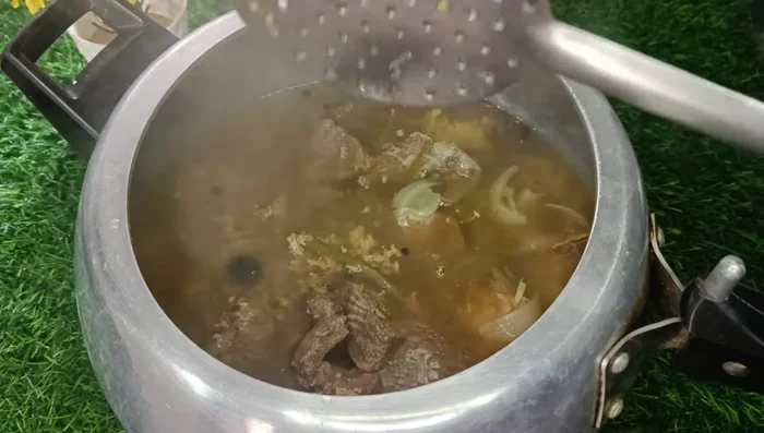 Allow pressure to release naturally. Strain the yakhni through a sieve, separating the meat and removing visible garlic.