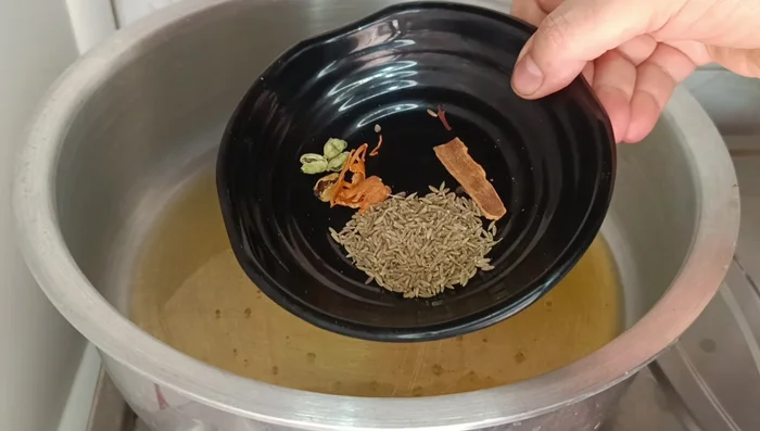 Heat 1 cup of oil in a pot. Add cumin seeds, cinnamon, cardamoms, and nutmeg; crackle for 8-10 seconds.