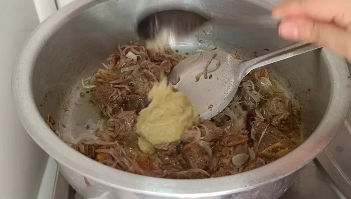 Add the cooked meat and garlic-ginger paste; fry for 3-4 minutes until the meat aroma is gone. Add a little water if needed.
