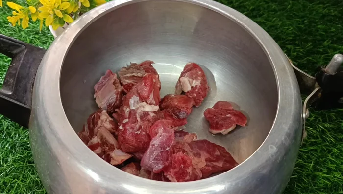 Transfer meat with fat to a cooker. Add whole coriander, fennel, chopped onion, slit green chilies, garlic, ginger, bay leaves, and whole garam masala (cardamoms, cumin, black pepper, cinnamon, star anise, cloves, nutmeg, mace).