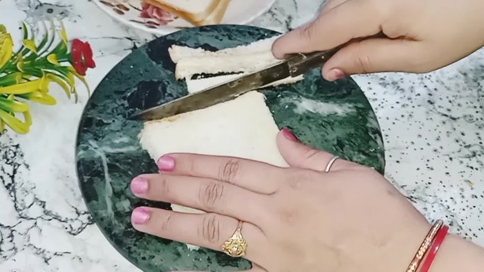 Remove the crusts from the bread slices and cut each slice into four pieces. You can use the crusts to make breadcrumbs.