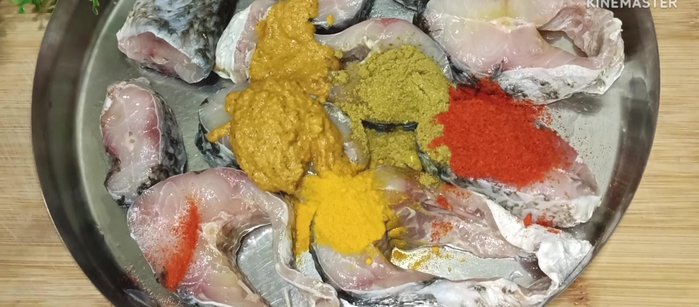 Marinate the fish: Add 2 tablespoons of the prepared masala paste, coriander powder, red chili powder, turmeric powder, and salt to the fish. Mix well and let it marinate for 15-20 minutes.