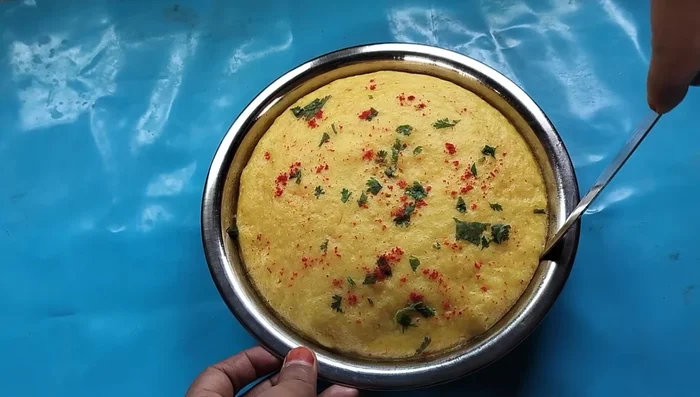 Let it cool for 5 minutes before demolding. Carefully run a knife around the edges to loosen the dhokla.