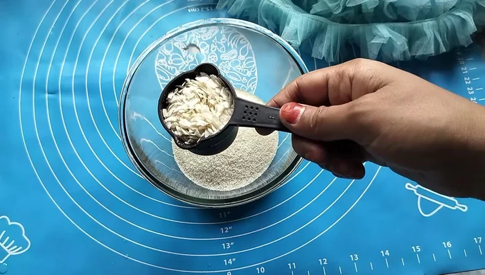 In a vessel, mix semolina (1 cup), 1/4 cup of the same measuring cup's worth of baking soda, and 1 cup of slightly sour curd.