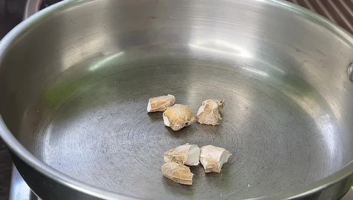 Fry dried ginger, peppercorns, cumin seeds, and dried chilies in the same pan for 1-2 minutes. Set aside to cool.
