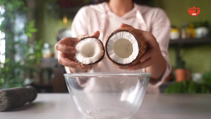 Add chopped coconut, mustard seeds, green chilies, cumin seeds, and a splash of water to a blender. Grind into a smooth paste.