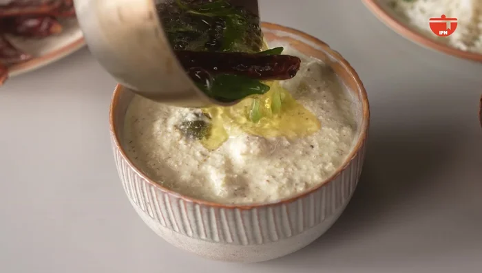 Pour the fragrant tempering over the cucumber and curd mixture.