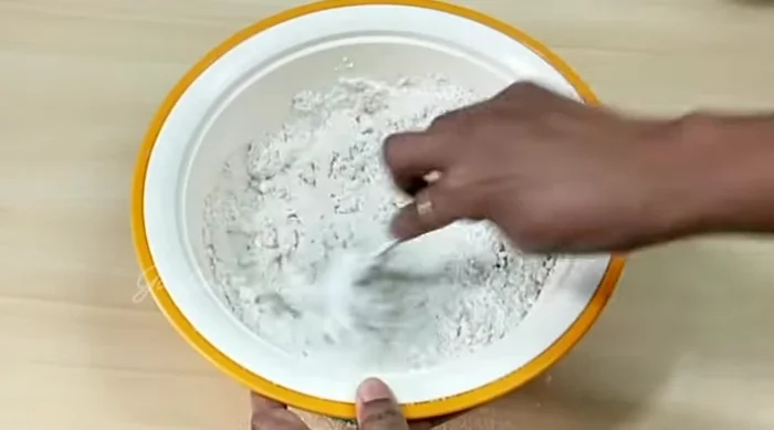 Combine the wet and dry ingredients. Knead with your hands, gradually adding warm water until a soft dough forms.