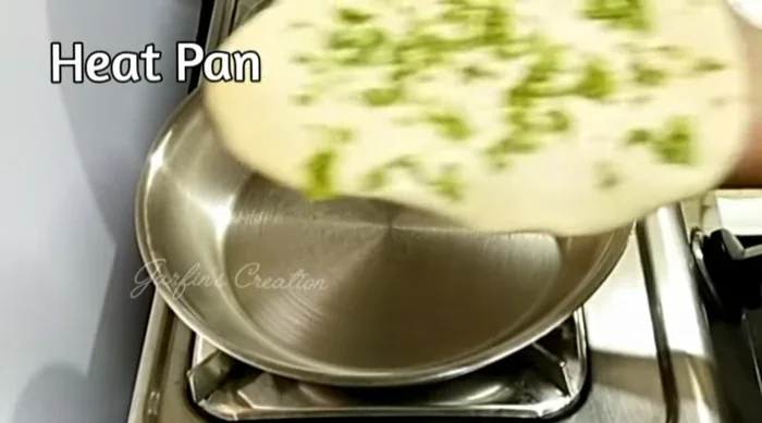 Heat a frying pan or tawa over medium-high heat. Apply water to the back of each naan to help it stick to the pan.