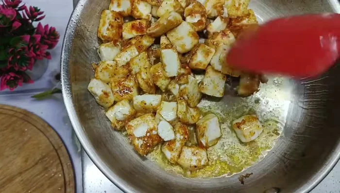 Remove excess oil from the fried paneer.