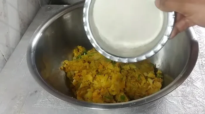 In a bowl, combine the vegetable mixture with the ground poha, green coriander, and mix well. Keep it under a fan for 2 minutes to cool down.