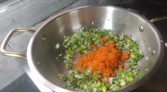 Grate carrots and add them to the pan. Fry the vegetables on high flame to retain their crunchiness.