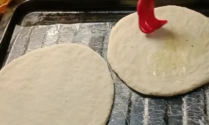 Apply a beaten egg wash over the naans using a brush or spoon.