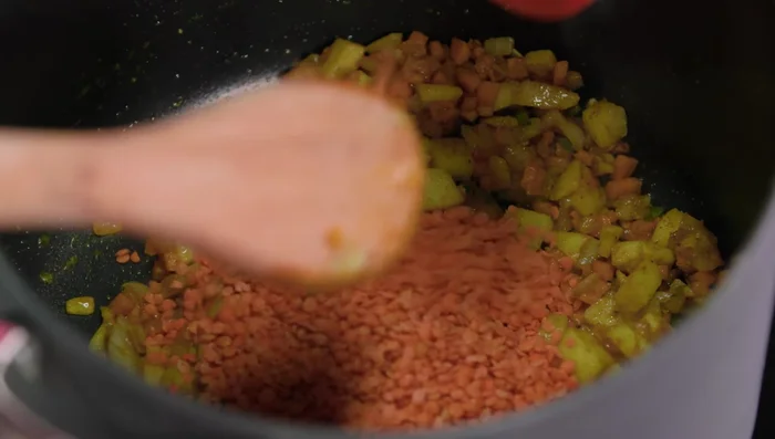 Add lentils (dry or pre-cooked). Sweat for a minute.