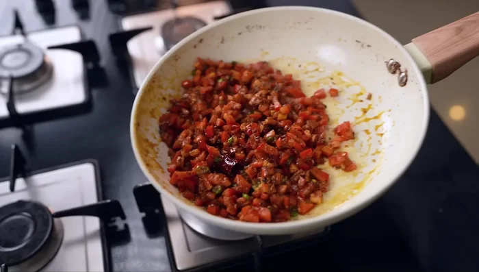 Add tomatoes: Add chopped tomatoes and fry until mashed. Season with salt, turmeric powder, red chili powder, and coriander powder.