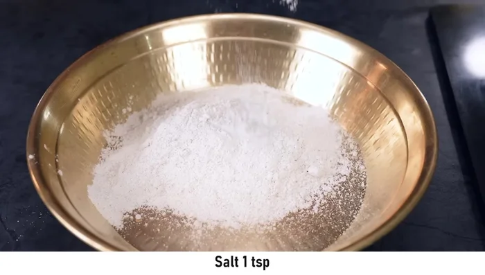 Add porridge: Pulse grind the porridge (daliya) and soak it in water. Add the soaked porridge to the flour mixture.