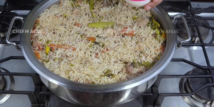 Add a little zarda color dissolved in water. Sprinkle fried onions, coriander, and mint on top.