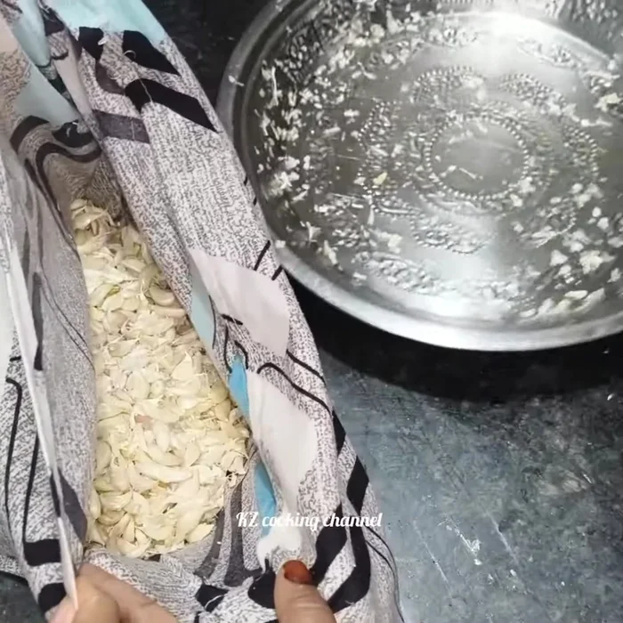 Place the oiled garlic cloves in a pillowcase or cloth bag and gently beat the bag to loosen the peel further. Avoid hitting it too hard to prevent breaking the garlic cloves.