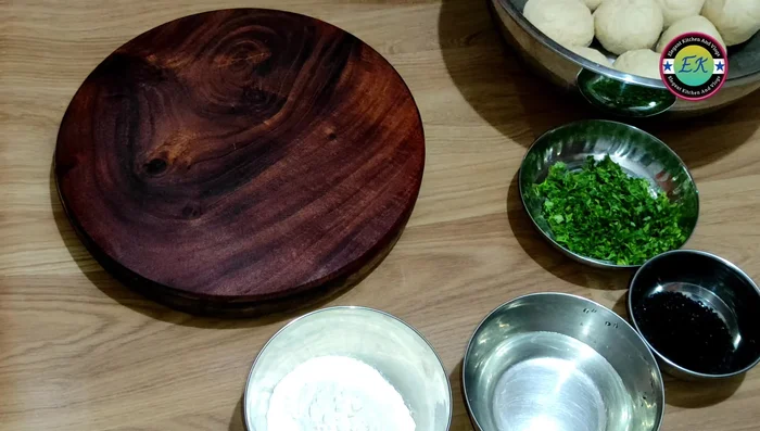 Roll each dough ball into a thin, round naan. Sprinkle with finely chopped coriander and kalanji.