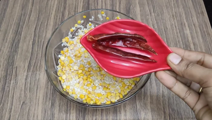 Drain the water and add red chilies and a small gooseberry-sized tamarind. Avoid adding too much tamarind.