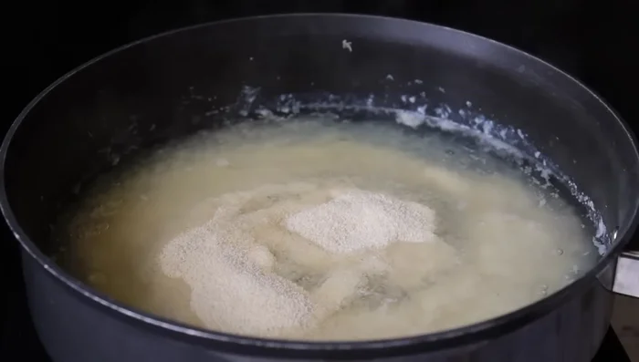 Add 1 cup of rava (semolina) to the cooked potato mixture and mix quickly to prevent lumps.