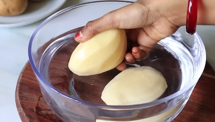 Peel and grate 2 medium-sized potatoes. Immediately place the grated potatoes in water to prevent browning.