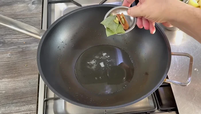 Heat coconut oil in a pan over medium heat. Add whole spices (bay leaves, cinnamon, cardamom) and cook for 90 seconds, crushing cardamom pods to release flavor.