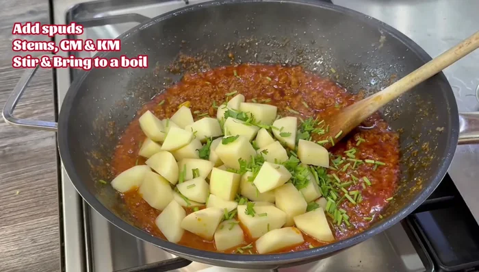 Add potatoes (2-inch cubes), coriander stems, and garam masala. Stir well. Bring to a boil, then add enough water to cover the potatoes (about 1 cup).