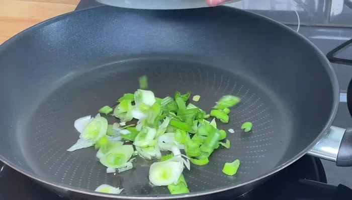 Fry spring onions in a little bit of the potato frying oil.
