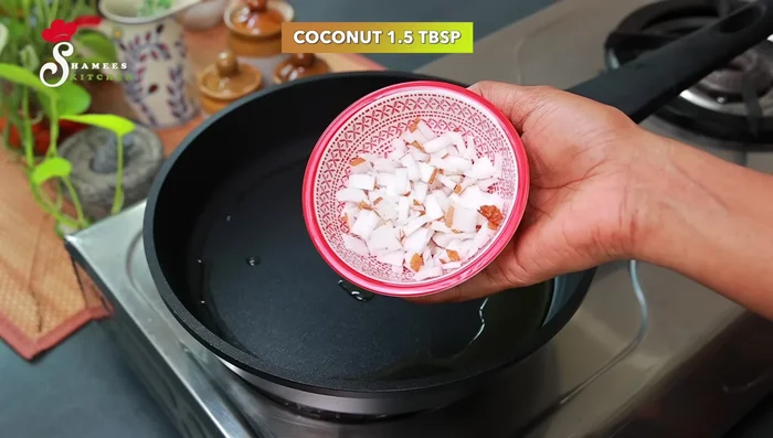 Heat a tablespoon of ghee in a pan. Add 1 1/2 tablespoons of finely chopped coconut slices and fry until lightly browned.