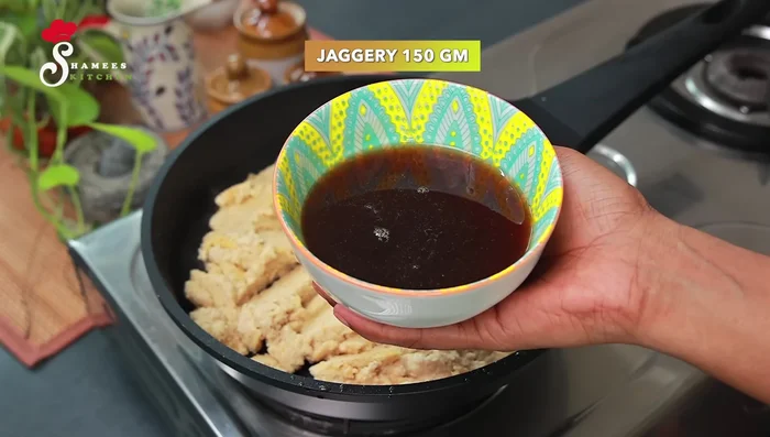 Add 150 grams of jaggery (dissolved in a quarter cup of water and filtered) to the mixture. Stir well to combine and remove lumps.