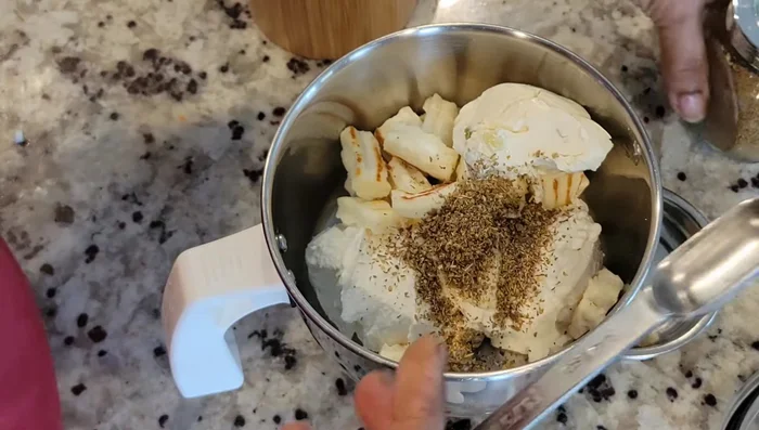 Combine hung curd, paneer cream cheese, roasted cumin, masala, salt, and vinegar in a blender or food processor (719.36).