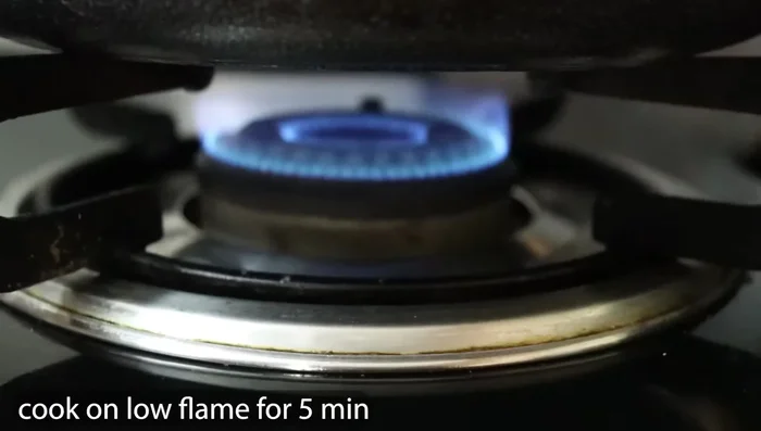 Place the paniyaram pan on a low flame, cover, and cook for 5 minutes.