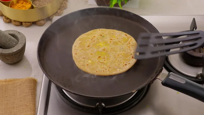 Increase the heat, press gently, and cook until golden brown and puffed up.